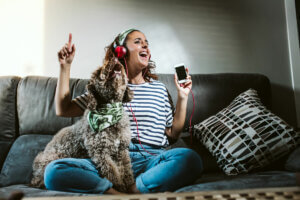 Une femme assise sur son canapé avec son chien.